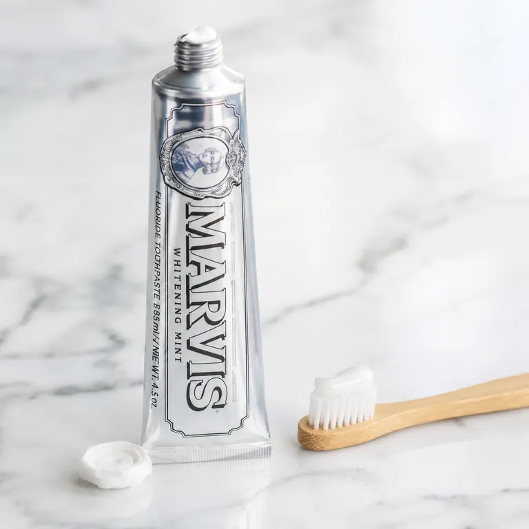Marvis Whitening Mint Toothpaste squeezed onto a wooden toothbrush