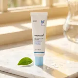 Medicube Zero Pore Moisture Sun Serum on marble surface in sunlight