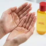 Applying Eqqualberry Vitamin C toner - dewy texture on hands 