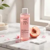 ANUA Peach 77 Niacin Essence Toner on white marble vanity with peach