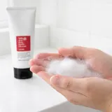 Hands lathering COSRX Salicylic Acid Cleanser into rich foam