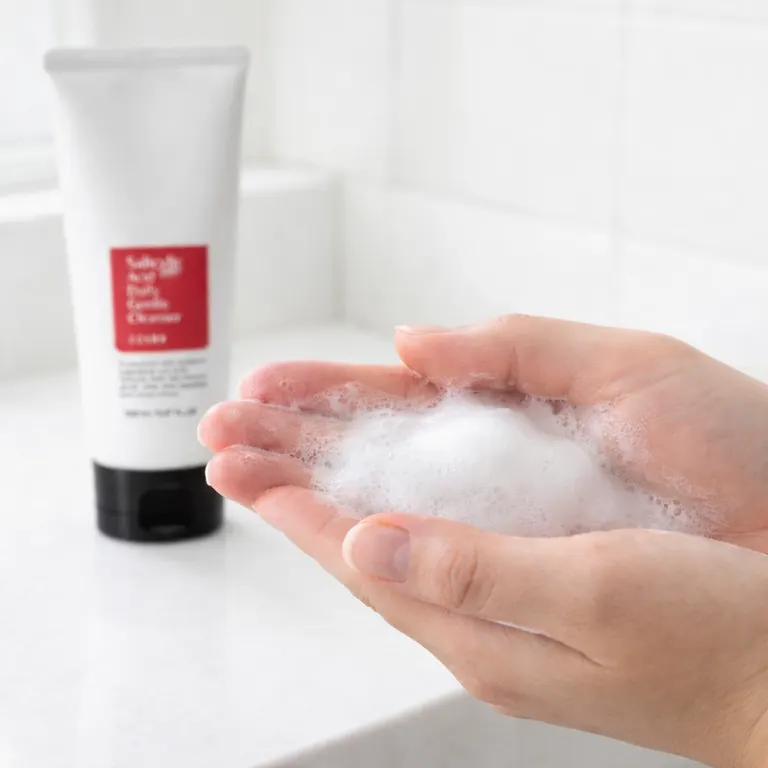 Hands lathering COSRX Salicylic Acid Cleanser into rich foam